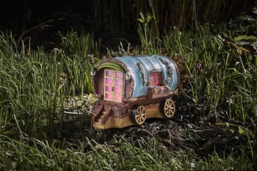 Preview: Ein kleines Feenhaus in Form eines Campingwagens beleuchtet im Garten